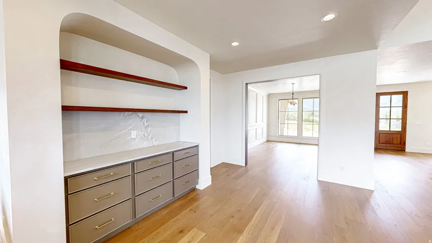 Built-in cabinetry with light-colored drawers, gold-finish hardware, and a stone-finish countertop