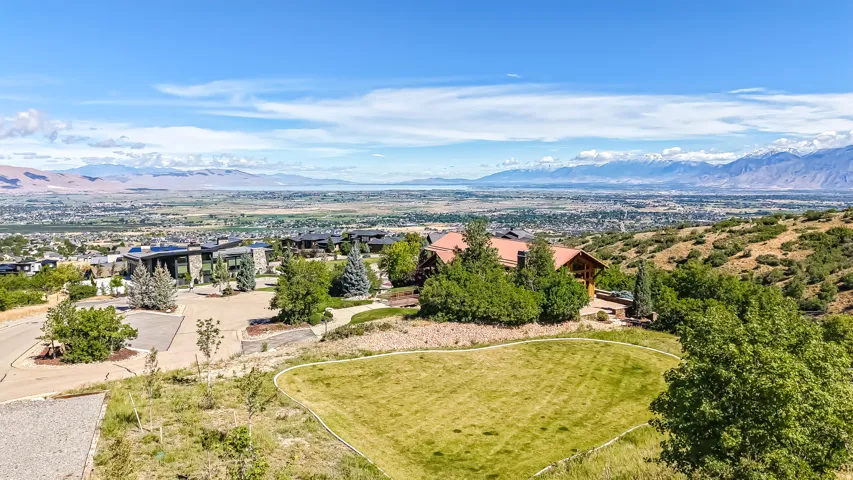 Expansive hillside property featuring a graded lawn area and established surrounding landscaping