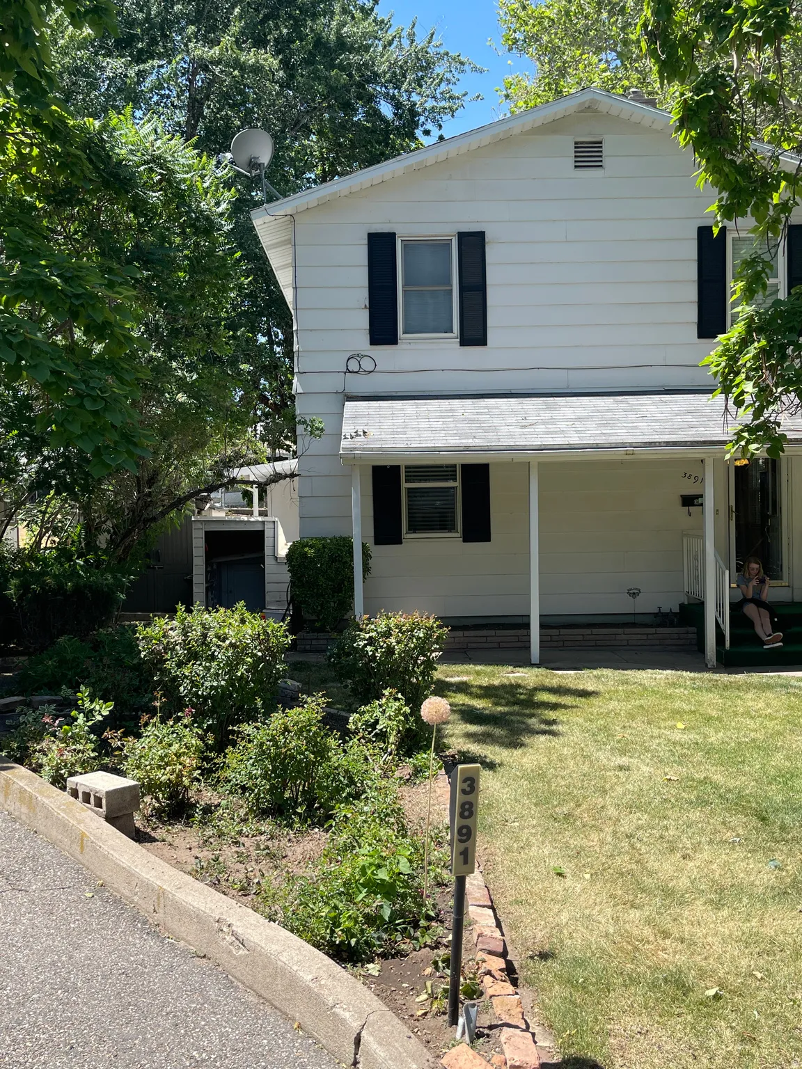 Two-story residence featuring white siding and dark shutters