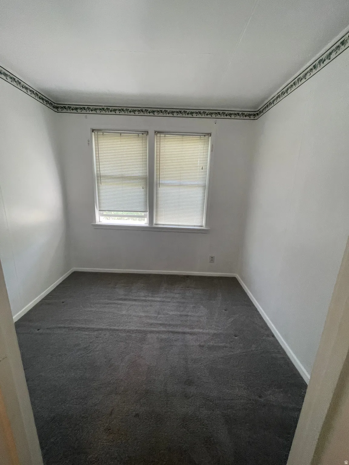 Interior room featuring dual windows with horizontal blinds, providing natural illumination