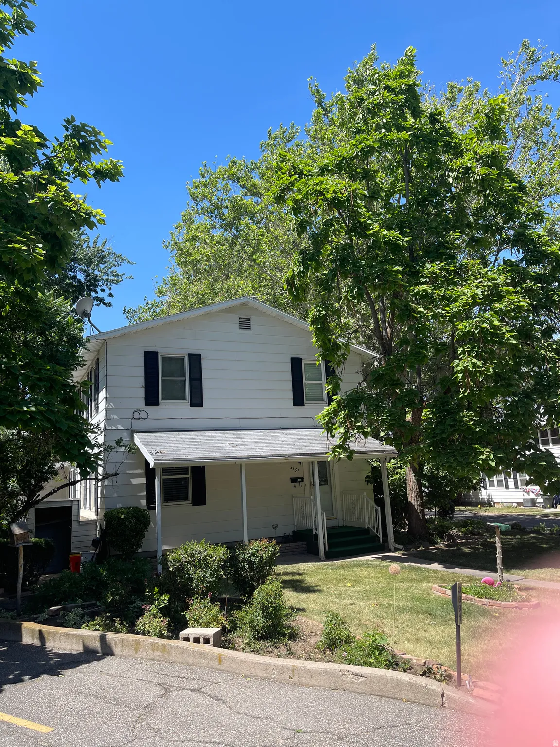 Two-story residence with white siding and black window shutters