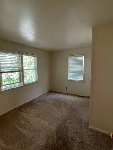 Room featuring neutral wall finishes and patterned carpeting