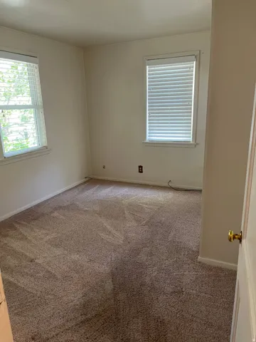 Neutral wall finishes and brown carpet flooring