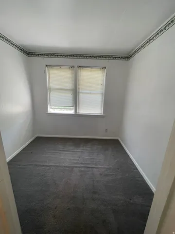 Interior room featuring dual windows with horizontal blinds, providing natural illumination