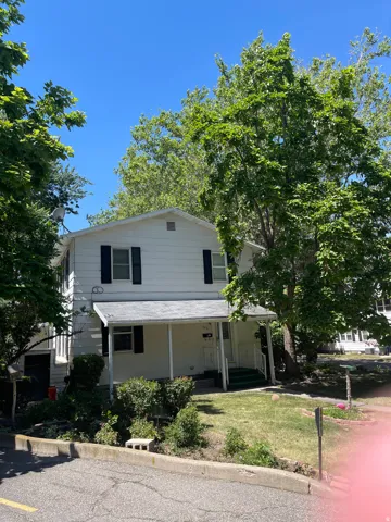 Two-story residence with white siding and black window shutters