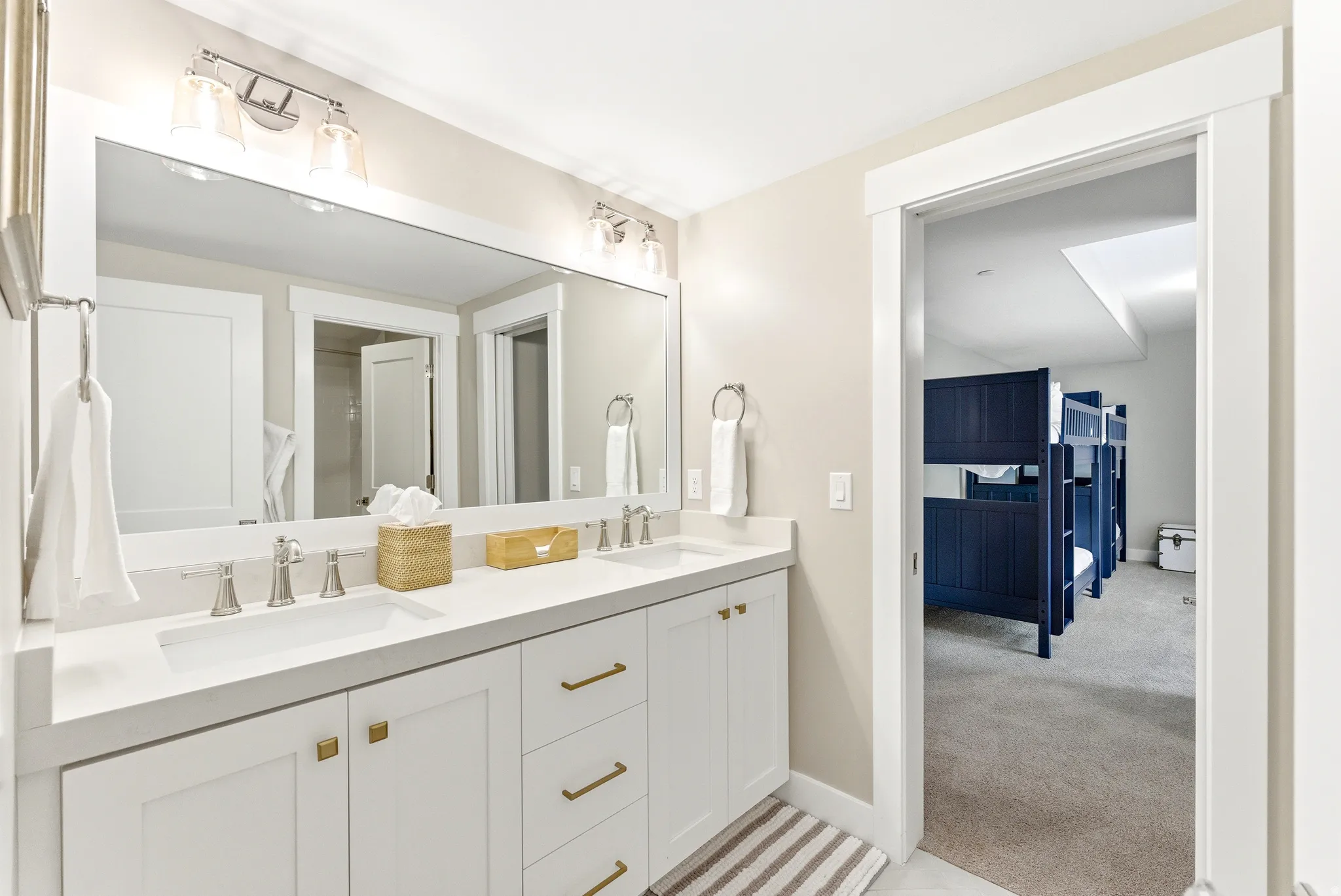 Double vanity featuring white cabinetry, light-colored countertops, and brushed nickel fixtures