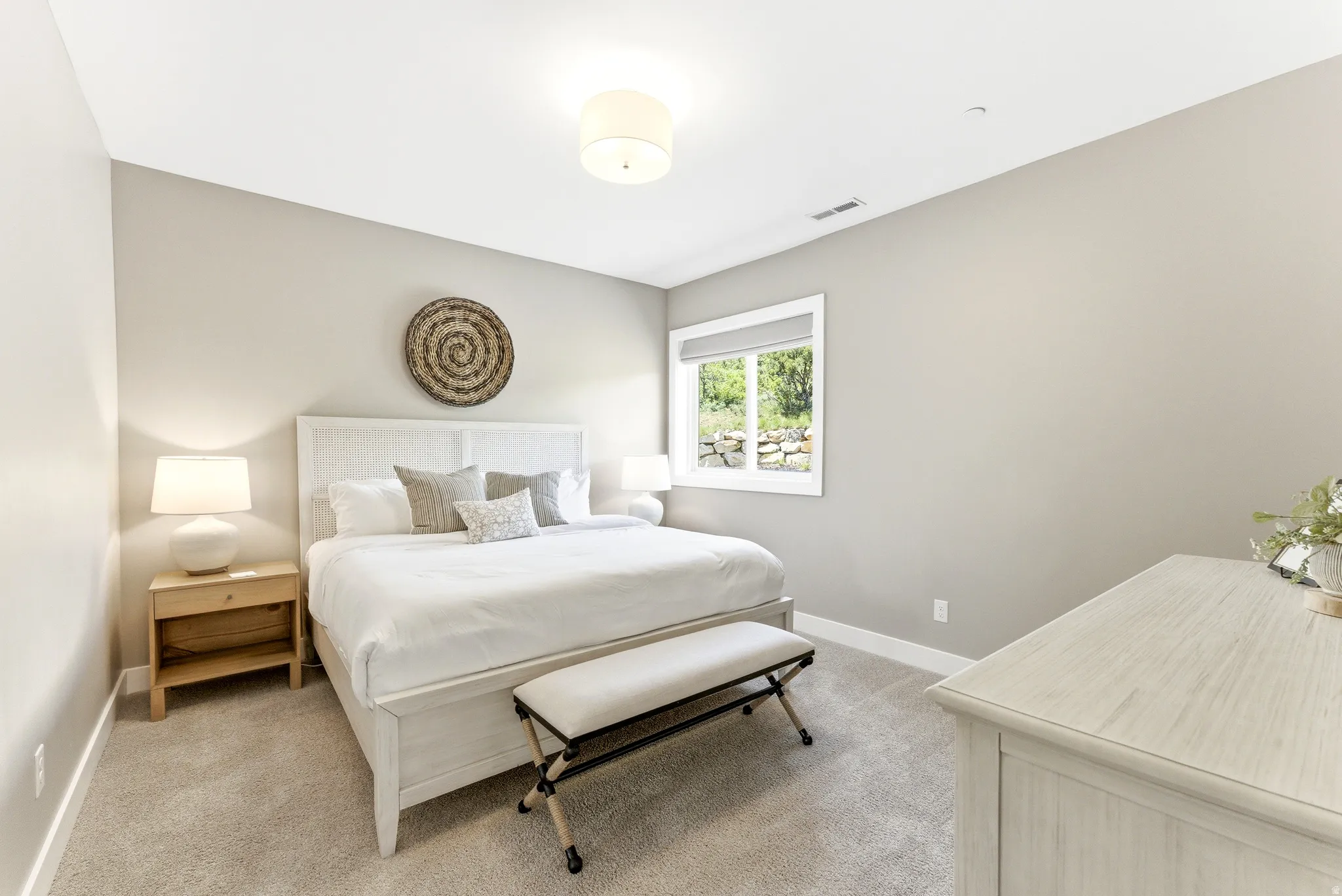 Carpeted room with a window featuring a roller shade, recessed lighting, and a drum ceiling light fixture