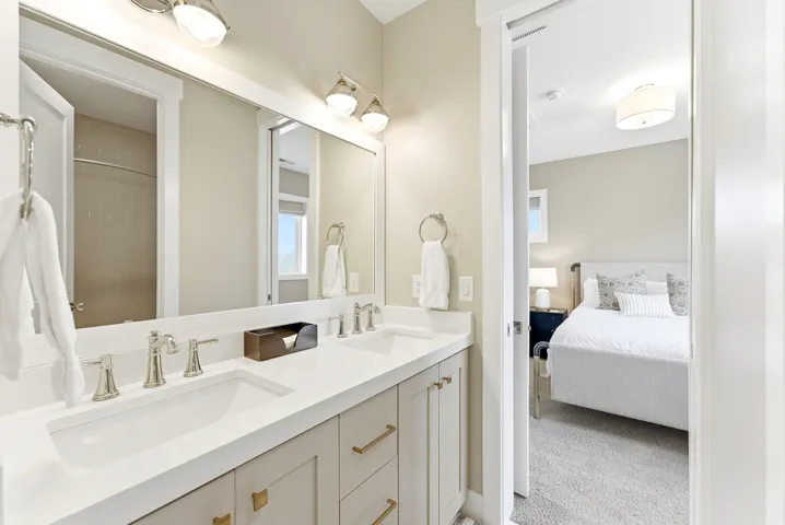 Bathroom vanity with dual undermount sinks, brushed nickel fixtures, and a white countertop