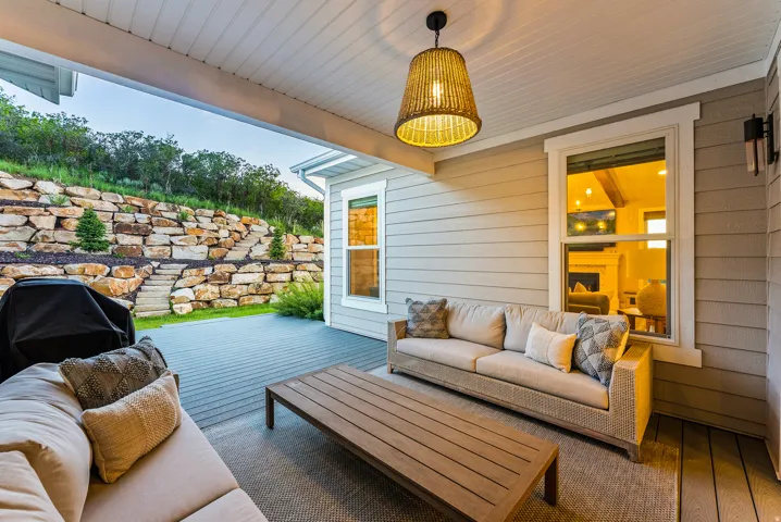 Covered patio featuring plank decking and a woven pendant light fixture