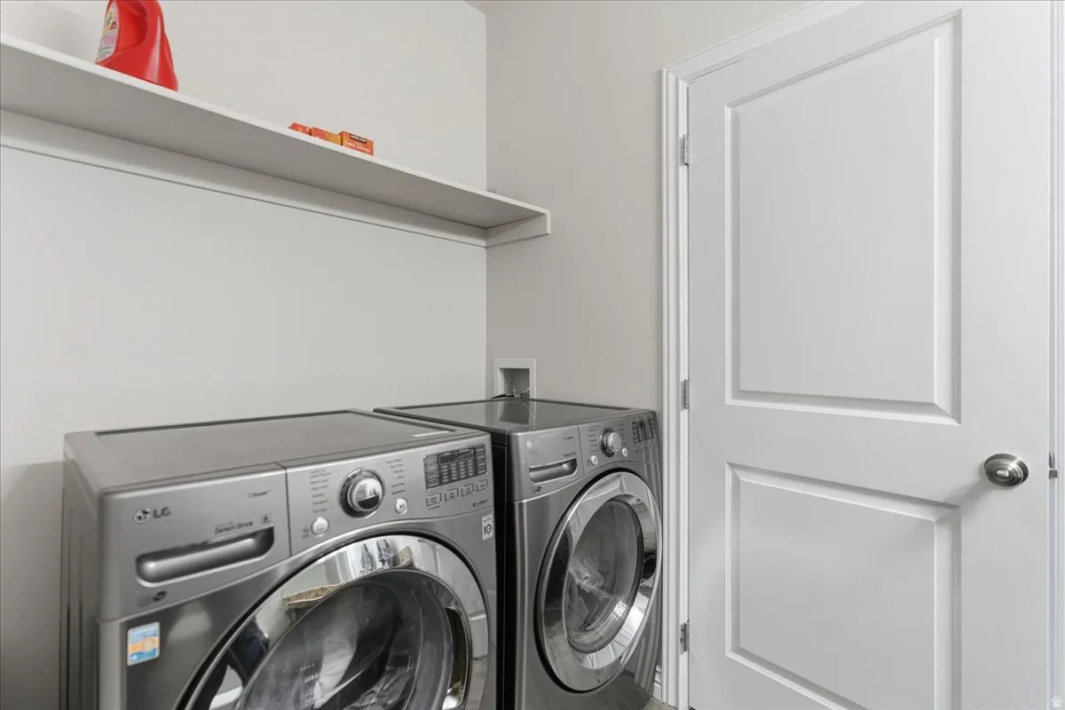 Dedicated laundry area featuring a wall-mounted shelf, light gray walls, and white trim