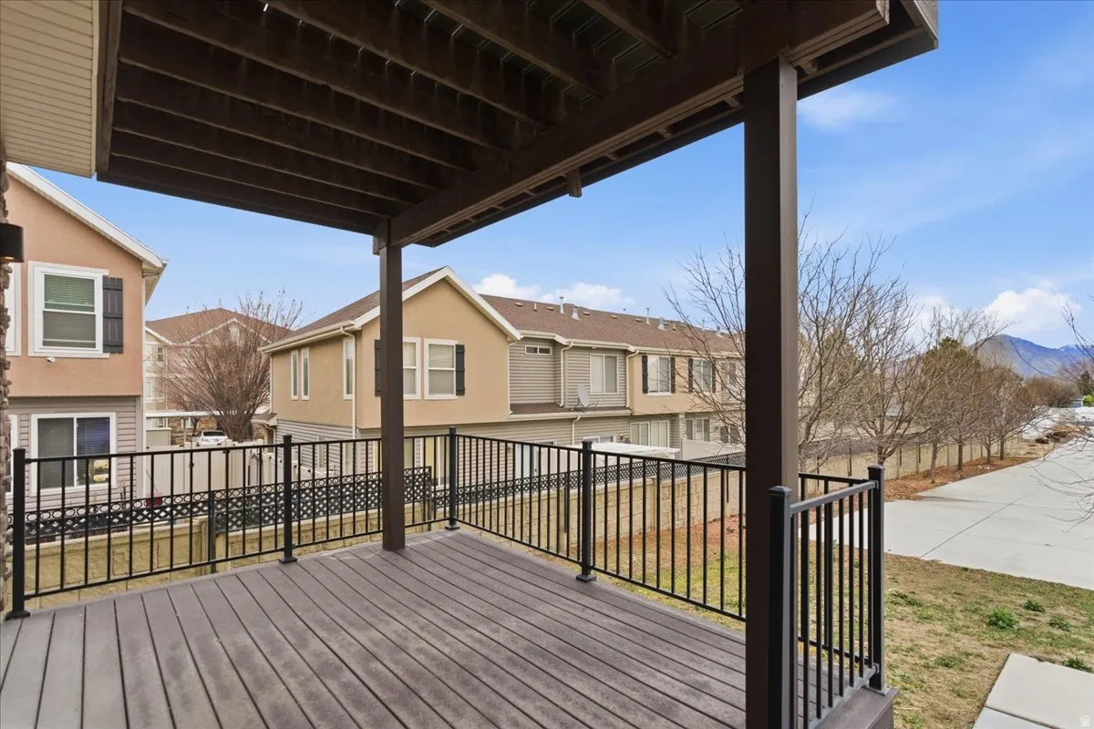 Upper-level deck featuring composite wood-finish decking and black wrought-iron railing