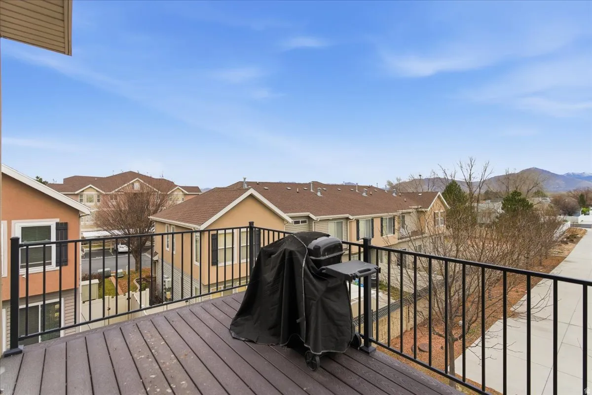 Wood-finish deck with a black metal railing and expansive neighborhood views