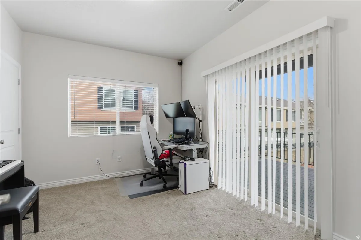 Spacious room featuring neutral carpeting and light gray walls