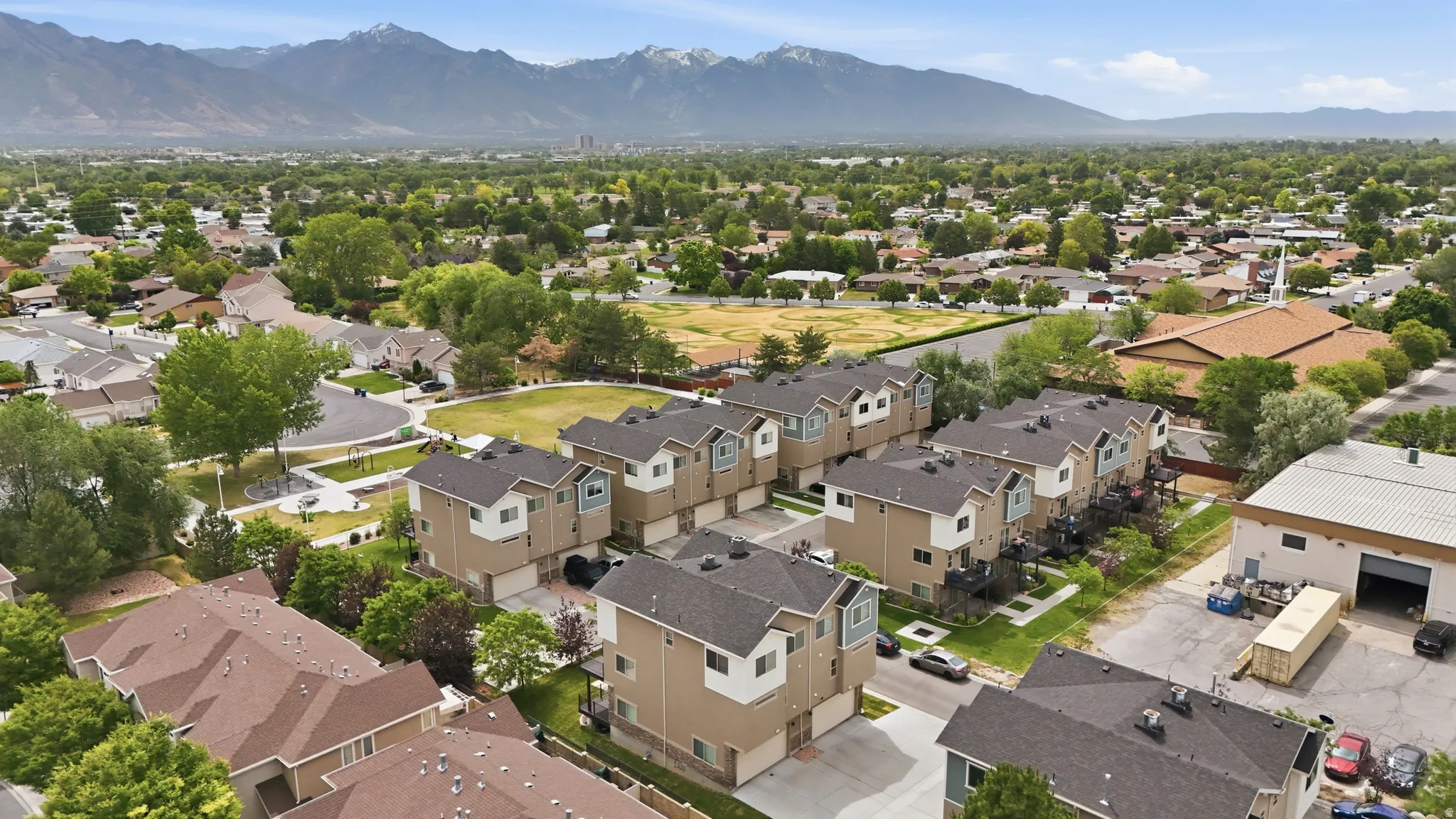 Townhome community with mountain backdrop, featuring two-story residences with attached garages and private balconies