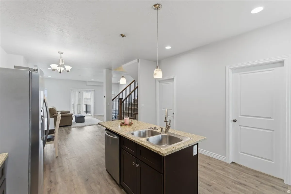 Kitchen island featuring a double-basin stainless steel sink and a granite-style countertop