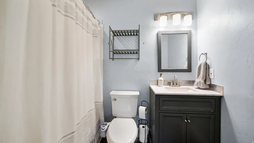 Bathroom featuring a dark vanity with a light-toned countertop