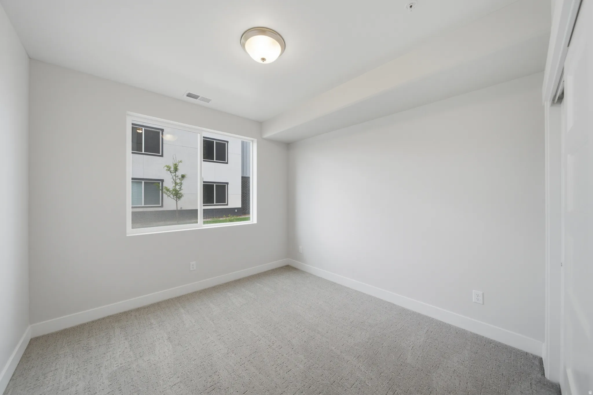 Bedroom featuring light gray walls, white trim, and gray patterned carpeting