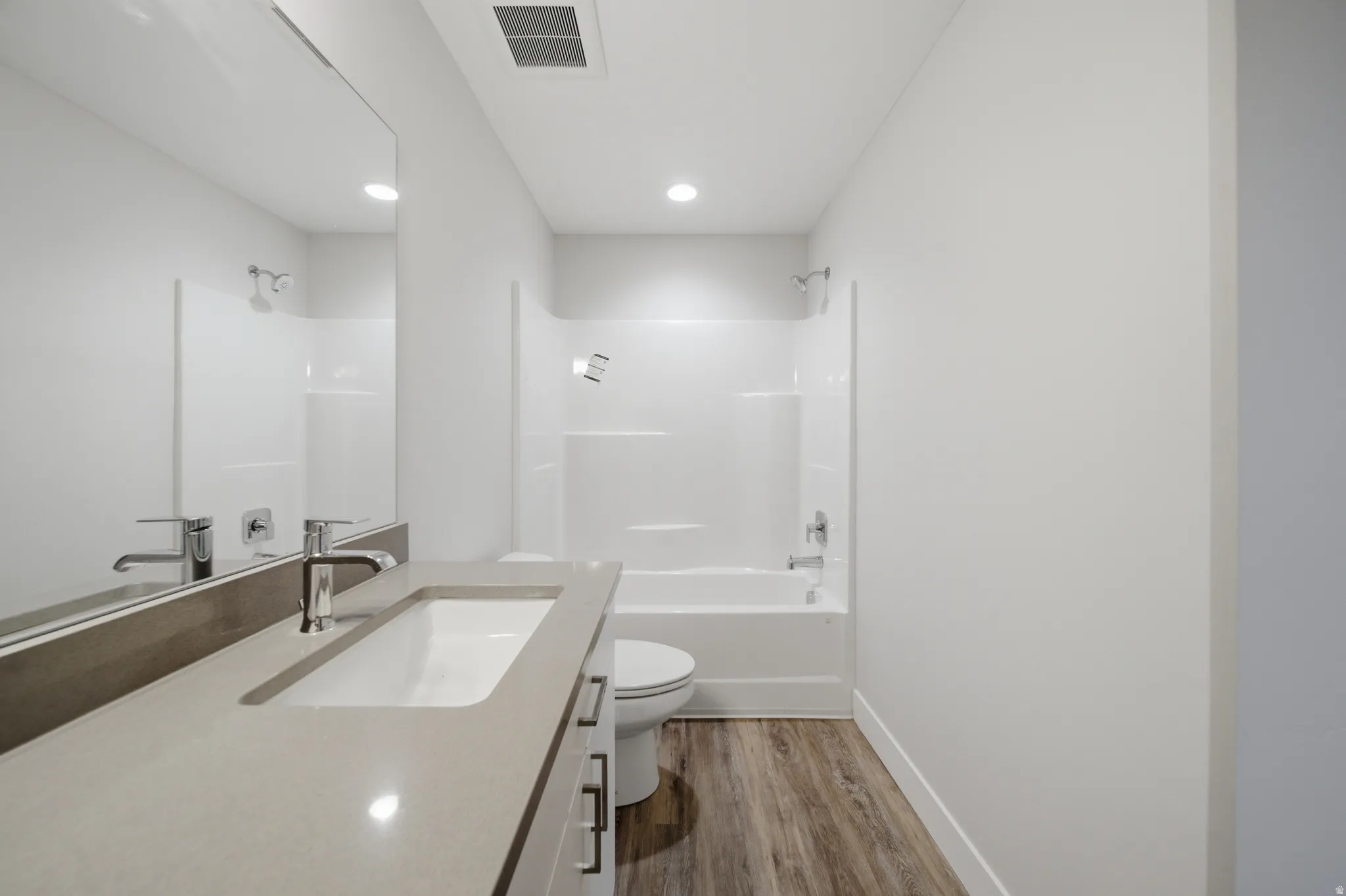 Modern bathroom featuring a single vanity with an integrated sink, a light-toned countertop, and chrome fixtures