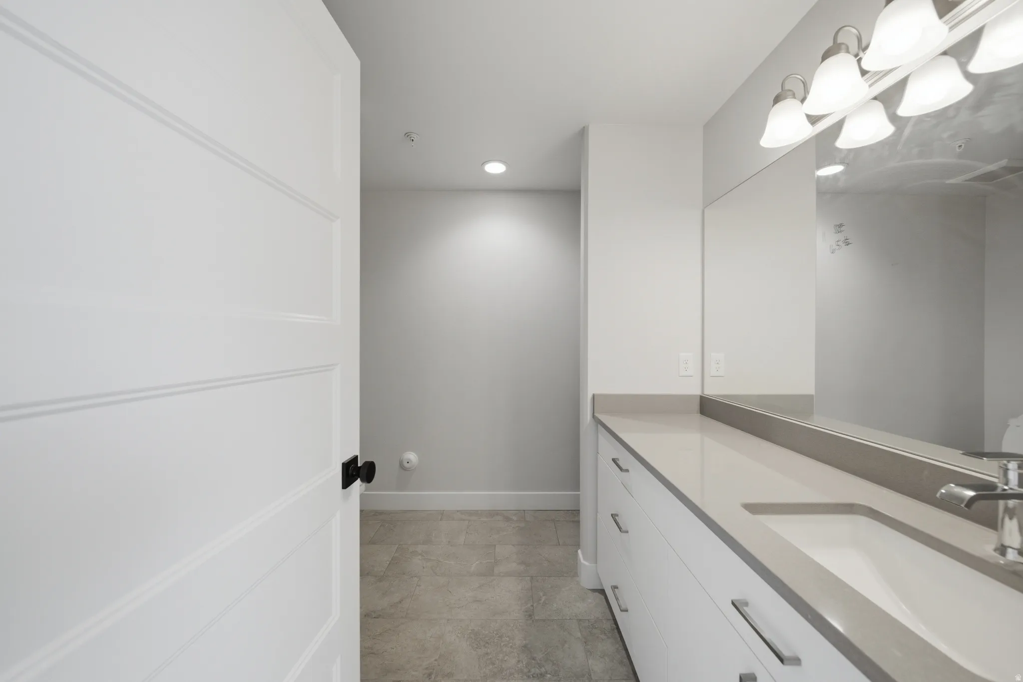 Vanity featuring an integrated sink, polished chrome faucet, and expansive mirror