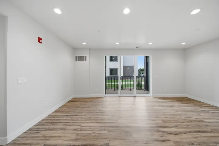 Bright, open room featuring wood-finish flooring, recessed lighting, and white baseboards