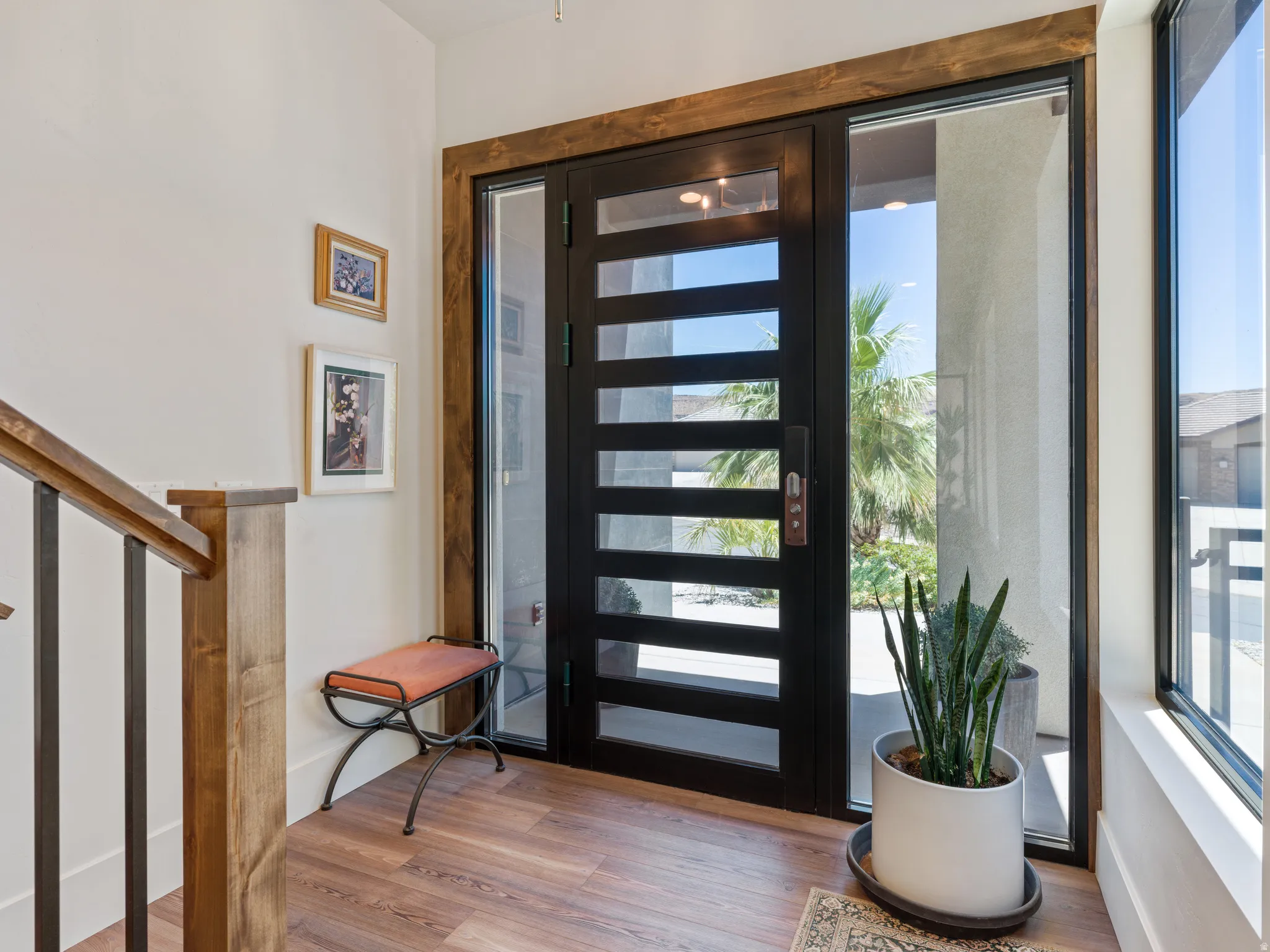 Modern entry door with horizontal glass panels, flanked by full-height sidelight windows