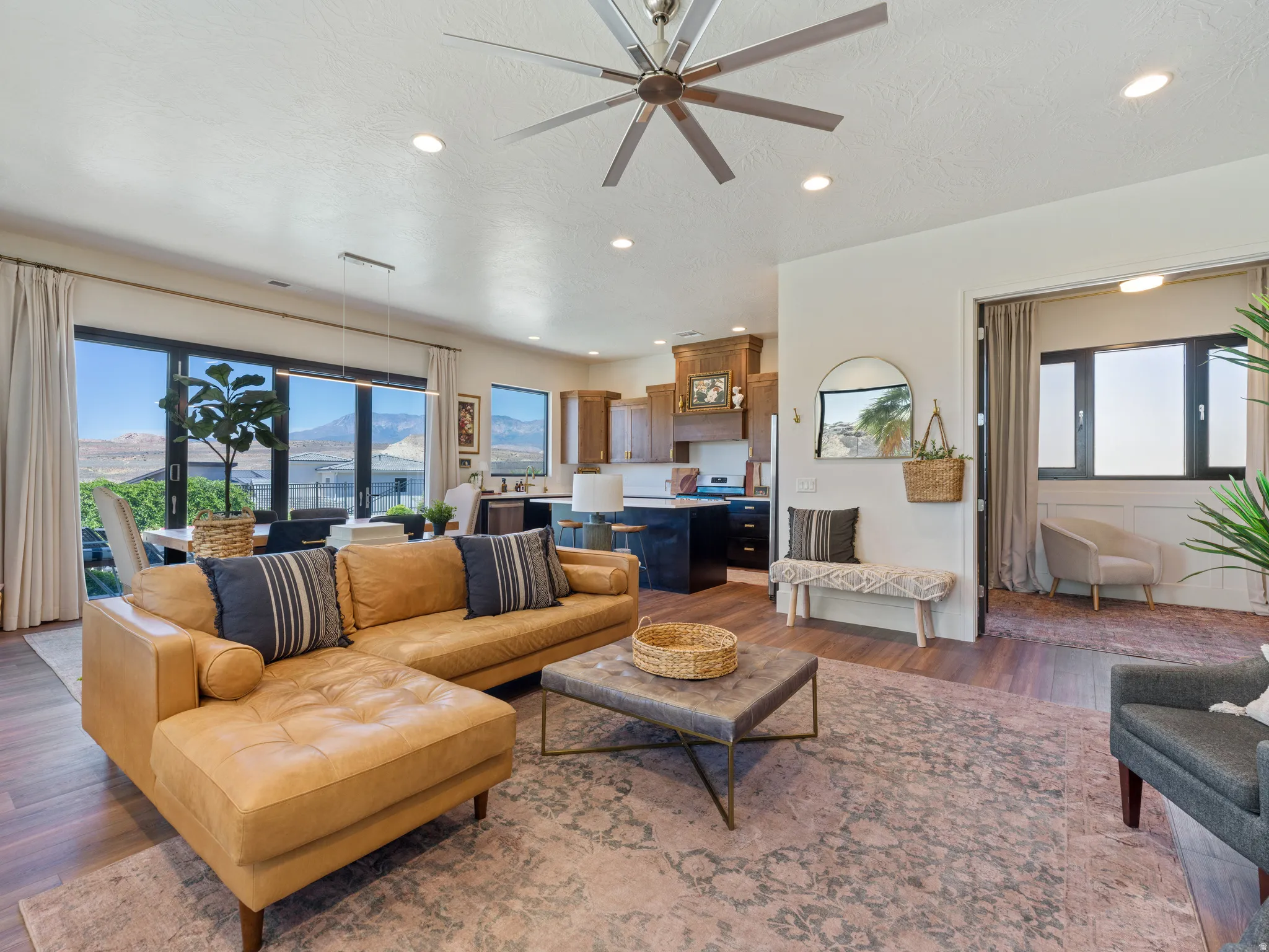 Open-concept living space with LVP, recessed lighting, and a modern ceiling fan
