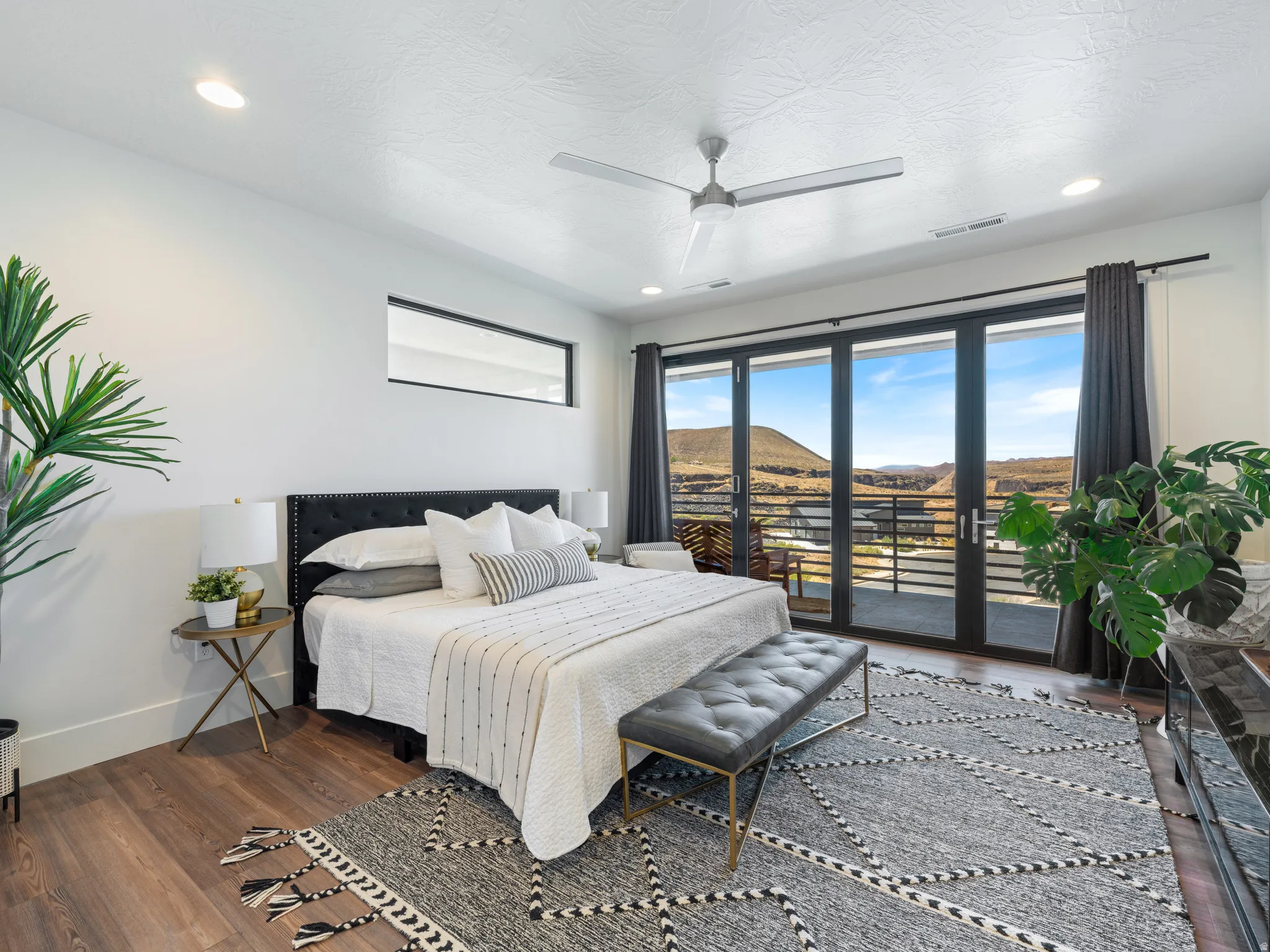 Spacious room featuring a wall of windows that open completely and a contemporary ceiling fan