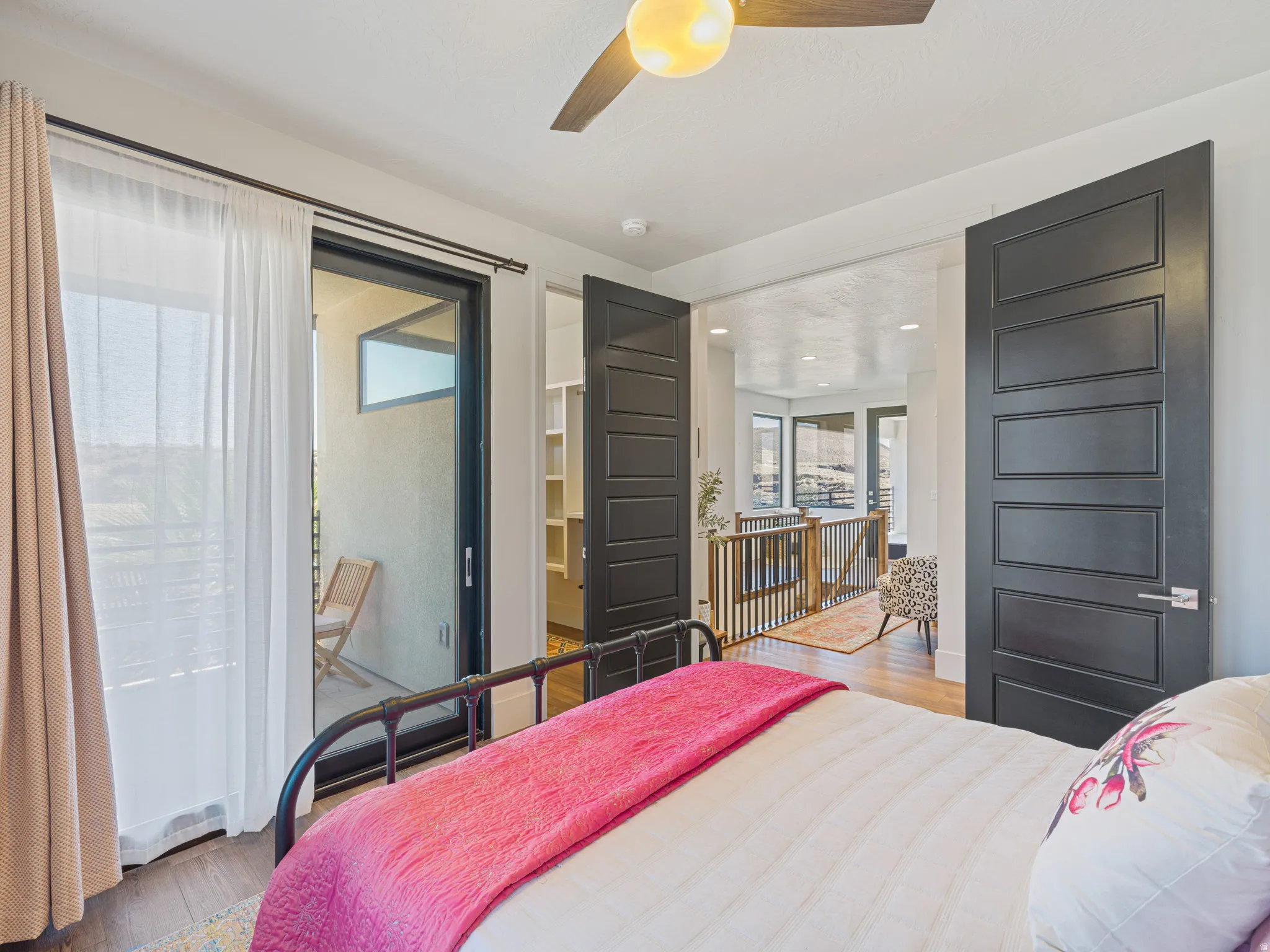 Room featuring  a contemporary ceiling fan with integrated lighting, and a large sliding glass door opening to an exterior balcony 2