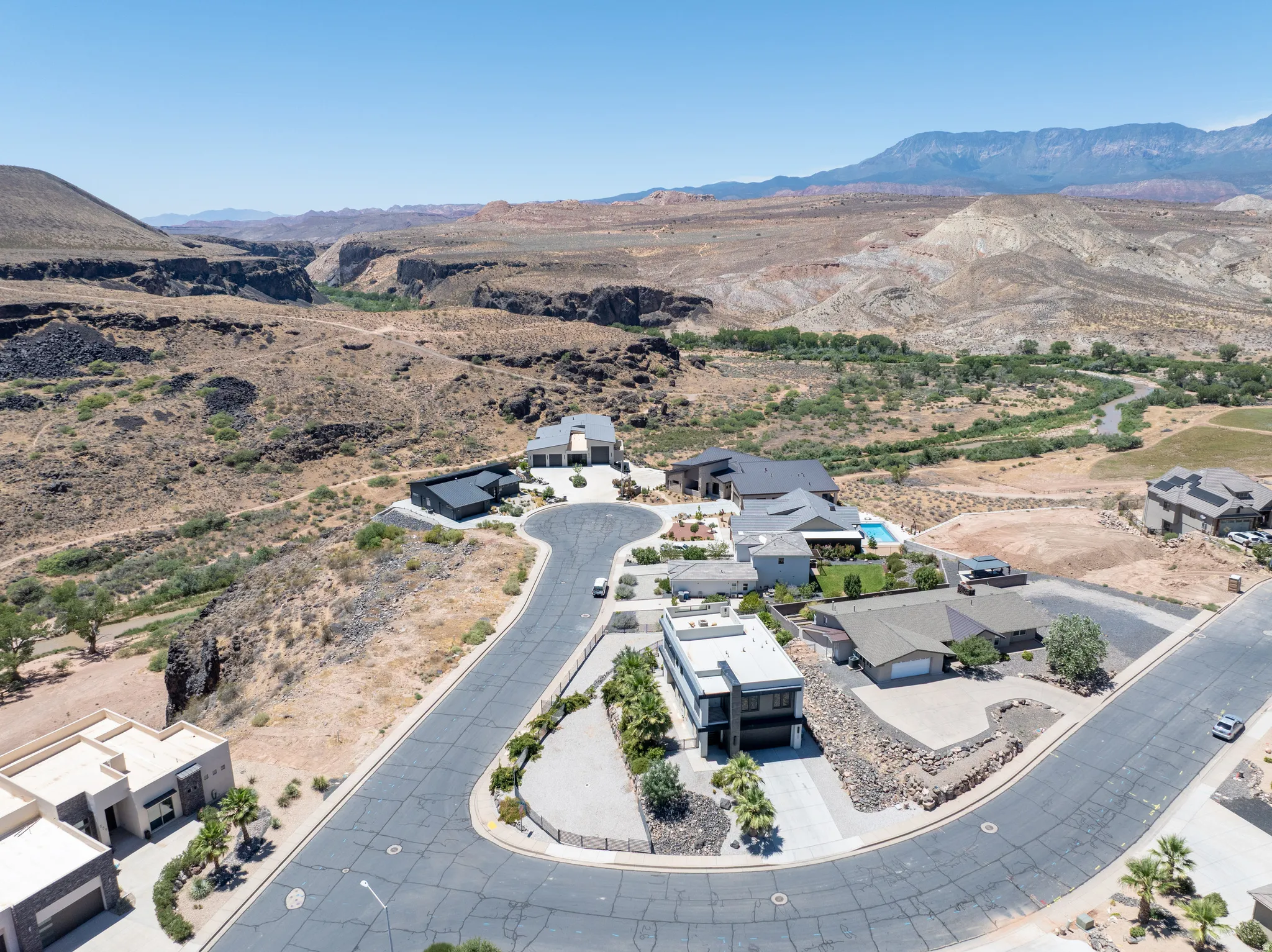 Aerial perspective showcasing a residential development with custom homes and a desert landscape