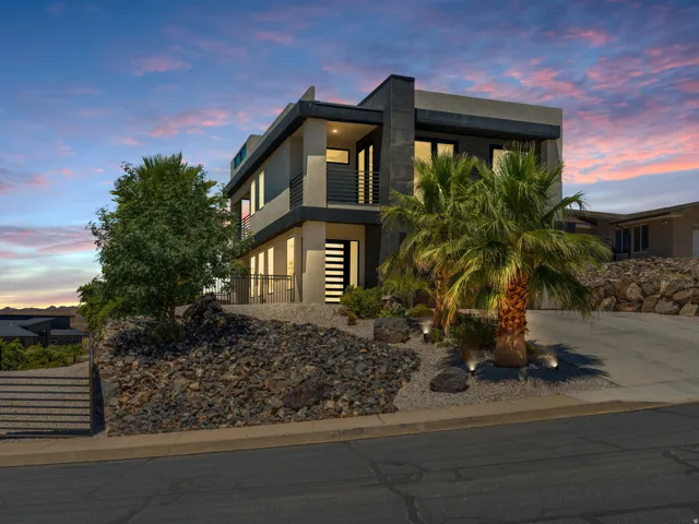 Contemporary multi-story residence featuring a flat roofline and integrated exterior lighting