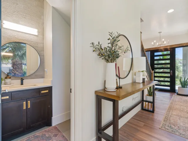 Entryway featuring LVP a contemporary chandelier, and a black-framed glass panel entry door