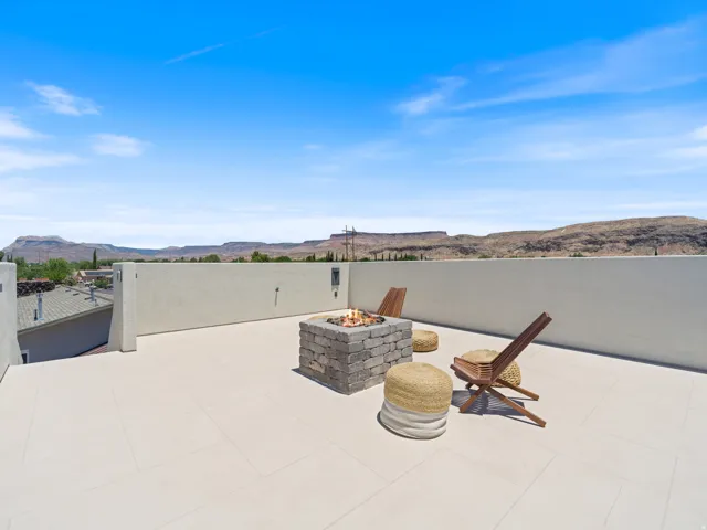 Rooftop patio featuring expansive tile flooring and a stone fire pit