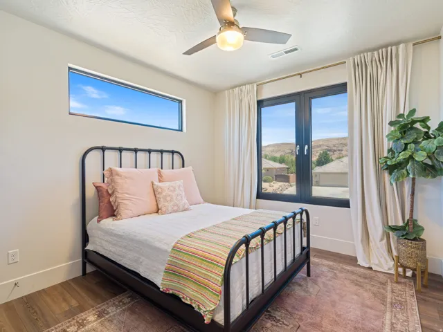 Expansive window views of distant hills,, a contemporary ceiling fan,all black windows and a high horizontal window
