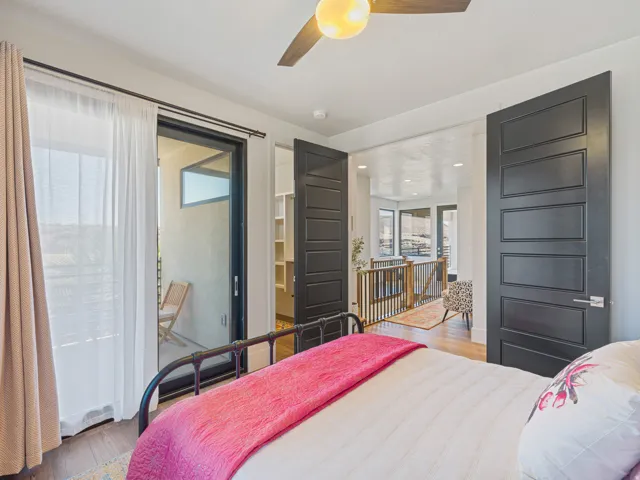 Room featuring  a contemporary ceiling fan with integrated lighting, and a large sliding glass door opening to an exterior balcony 2