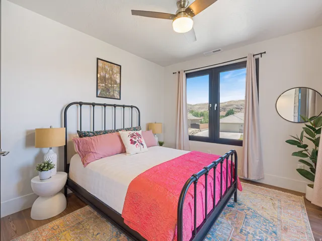 Bedroom featuring a window with a mountain backdrop a ceiling fan, and white walls