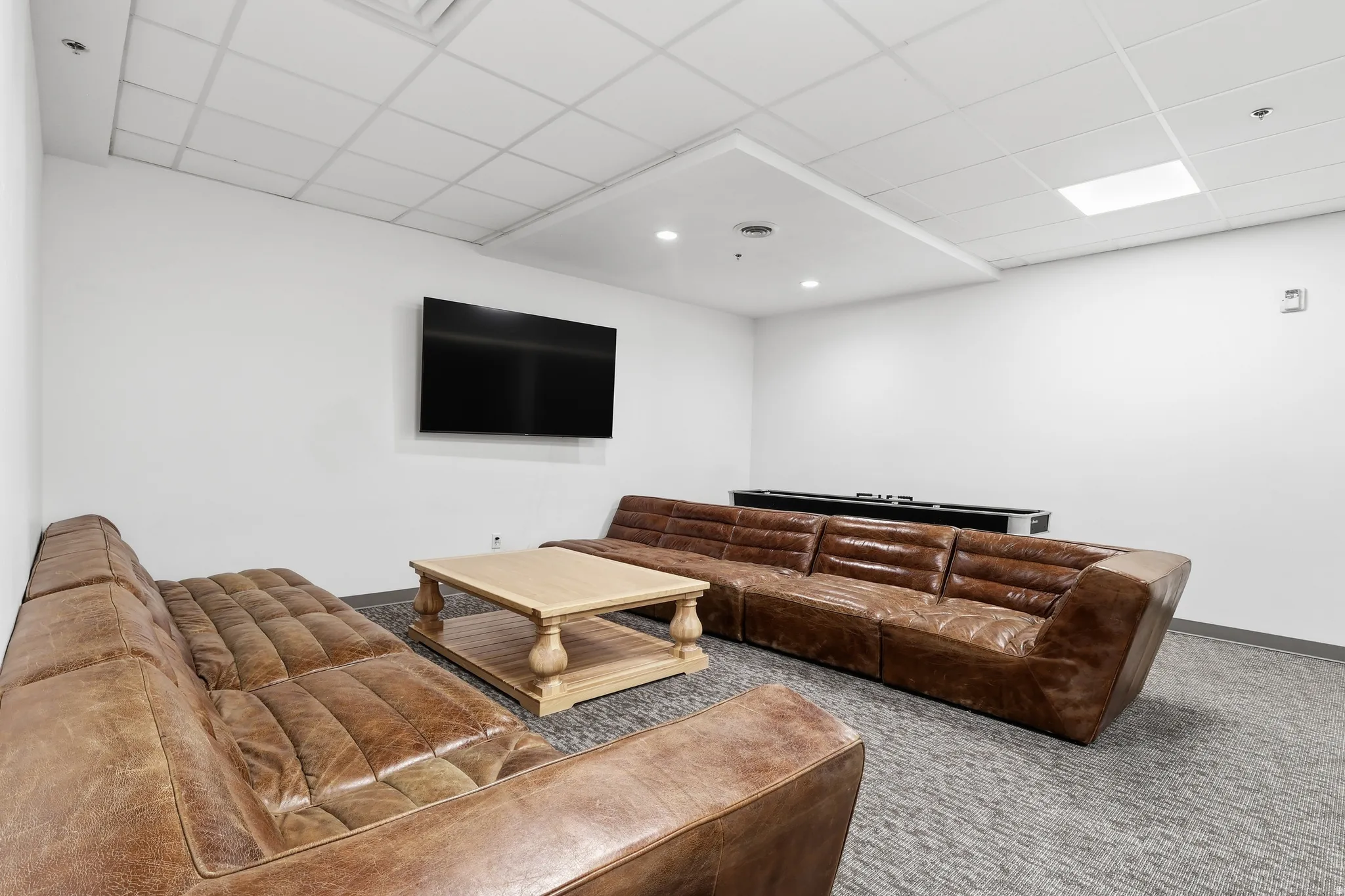 Spacious room featuring neutral wall paint, gray patterned carpeting, and recessed lighting