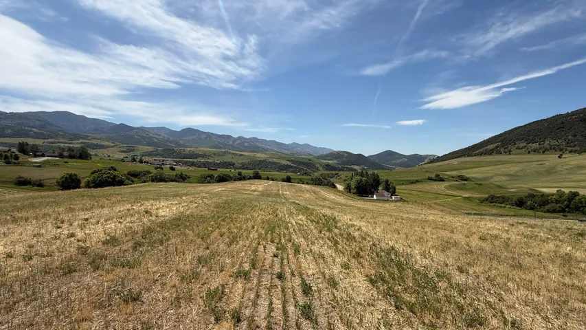 Expansive land parcel featuring rolling hills and distant mountain ranges