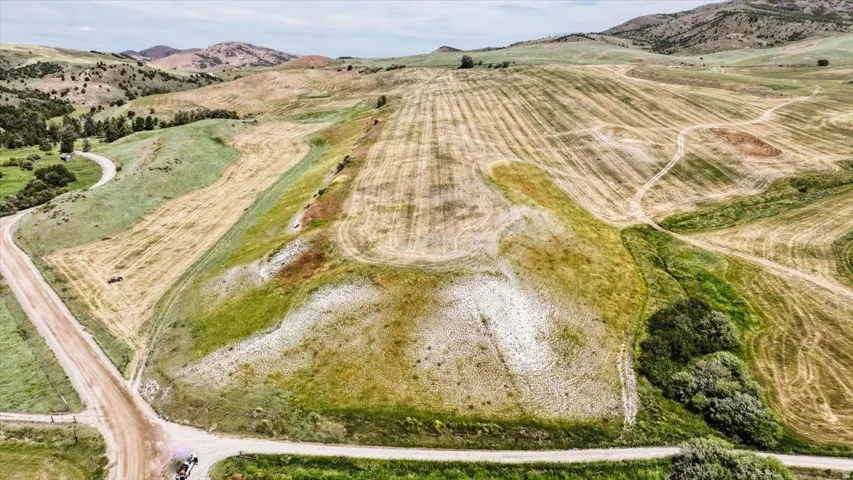 Expansive rolling terrain featuring a mix of cultivated fields and natural grasslands
