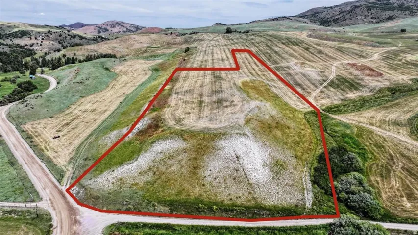 Expansive parcel of land featuring varied topography, including rolling hills and flat areas