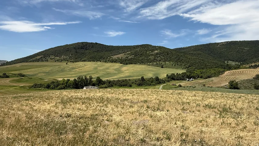 Expansive rural landscape featuring rolling hills and distant mountains
