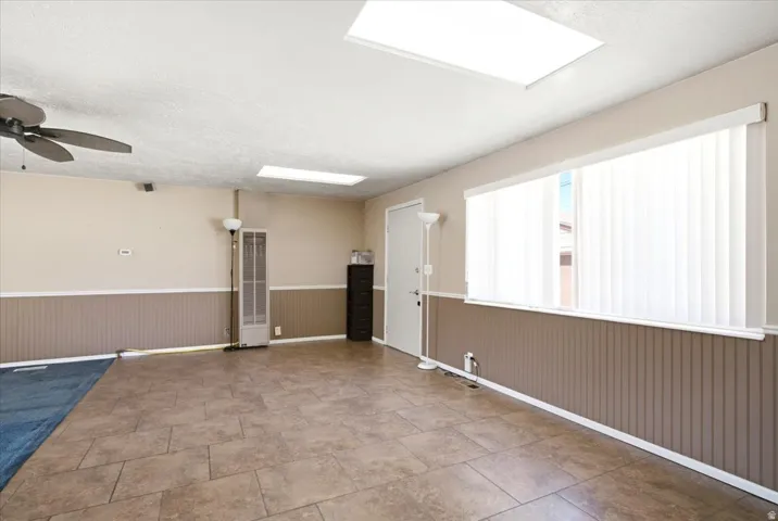 Spacious interior featuring tile flooring and wainscoting