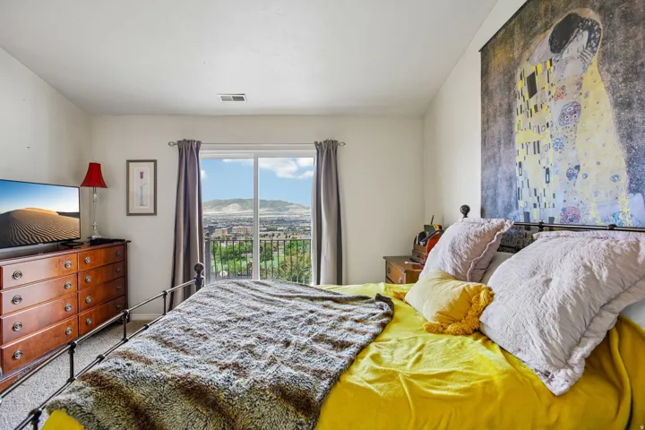 Sliding glass door opening to a balcony with mountain and city topography