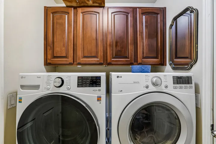 Dedicated laundry area featuring overhead wood cabinetry
