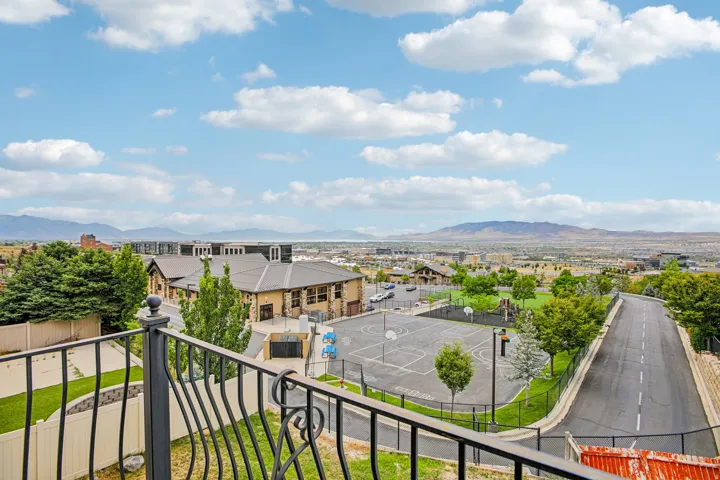Expansive city and mountain scenery framing an outdoor basketball court, green space, and surrounding structures