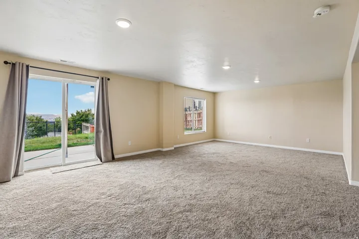 Spacious room featuring neutral carpeting and light-colored walls