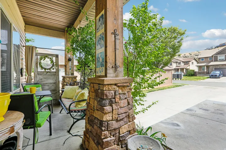 Covered porch featuring a wood-finish plank ceiling and stone-clad column