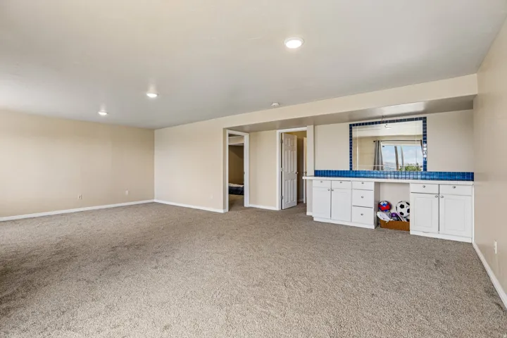 Spacious room featuring neutral carpeting and recessed lighting