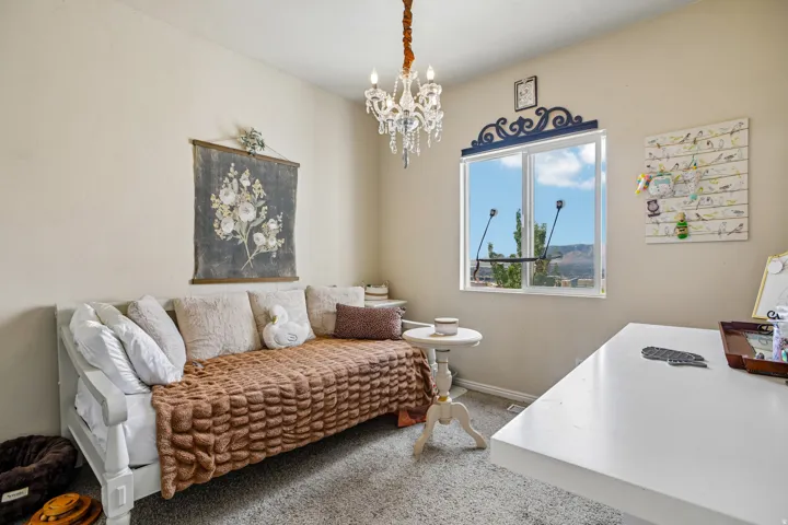 Room featuring a crystal chandelier, neutral wall paint, and a large window with an ornate valance