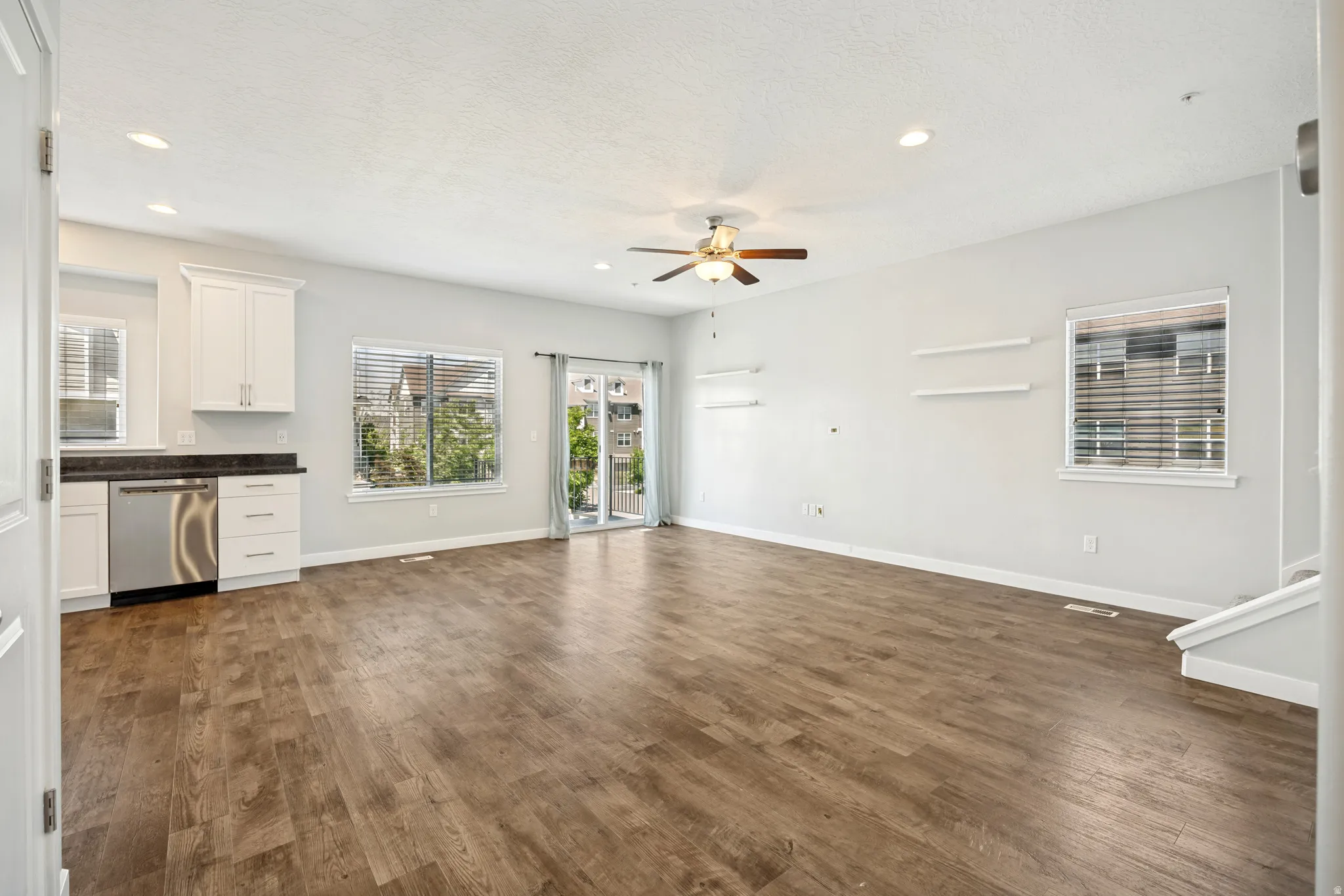 Open-concept living space featuring laminate flooring, recessed lighting, and a ceiling fan.