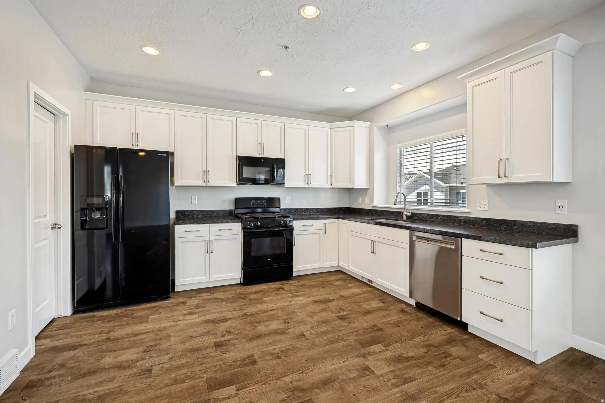 A generously sized kitchen showcasing clean, modern white cabinetry.